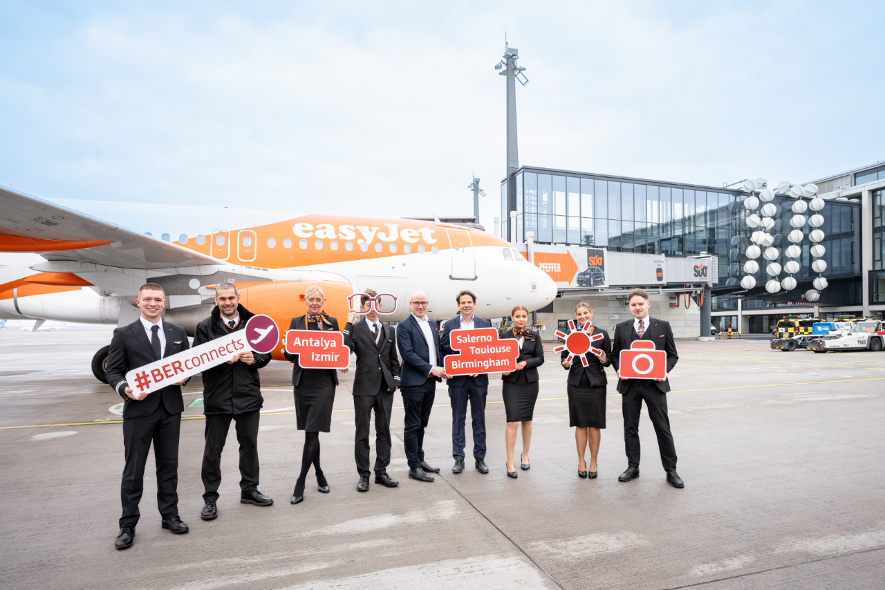 People with signs standing in front of an EasyJet aircraft