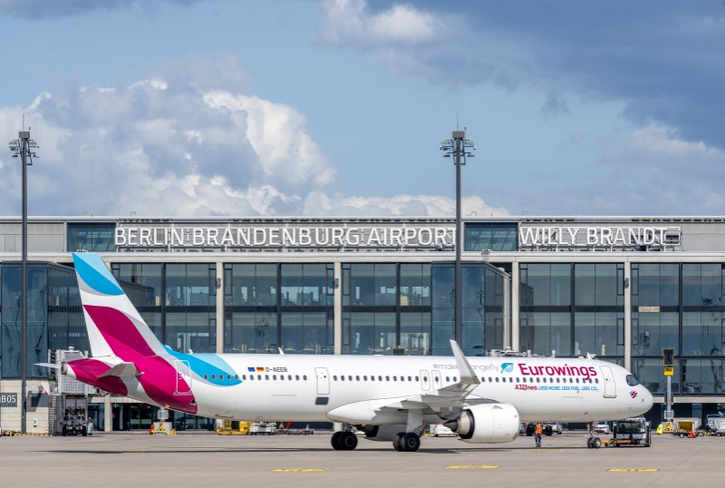 Eurowings aircraft on the apron of BER. Behind it, Terminal 1 with the Berlin Brandenburg Airport Willy Brandt lettering