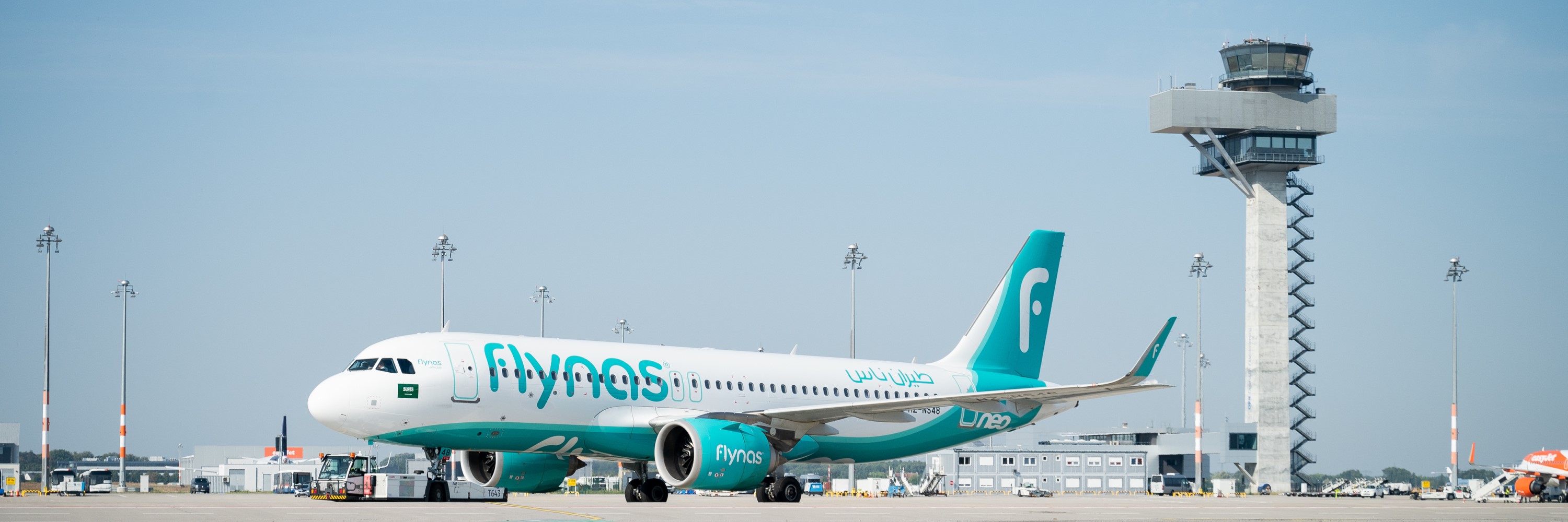 Aircraft of the airline flynas at BER. The tower in the background.