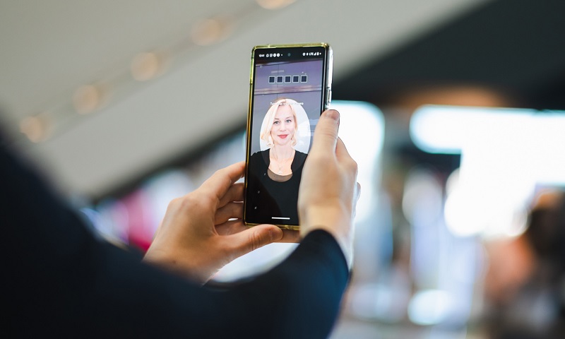 Frau legt biometrisches Profil an. Schaut in ein Mobile