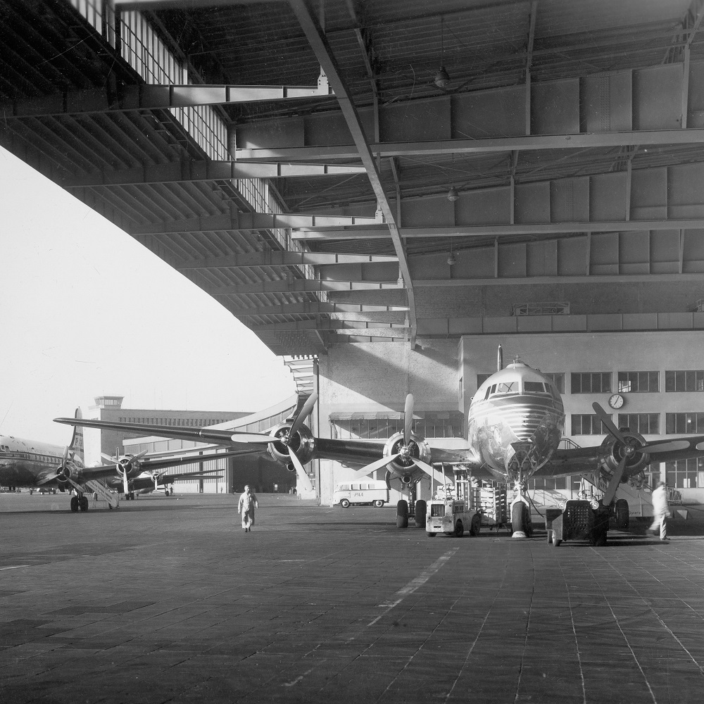 Schwarz Weiß Foto vom Flughafen Tempelhof. Propellerflugzeug steht im Hangar