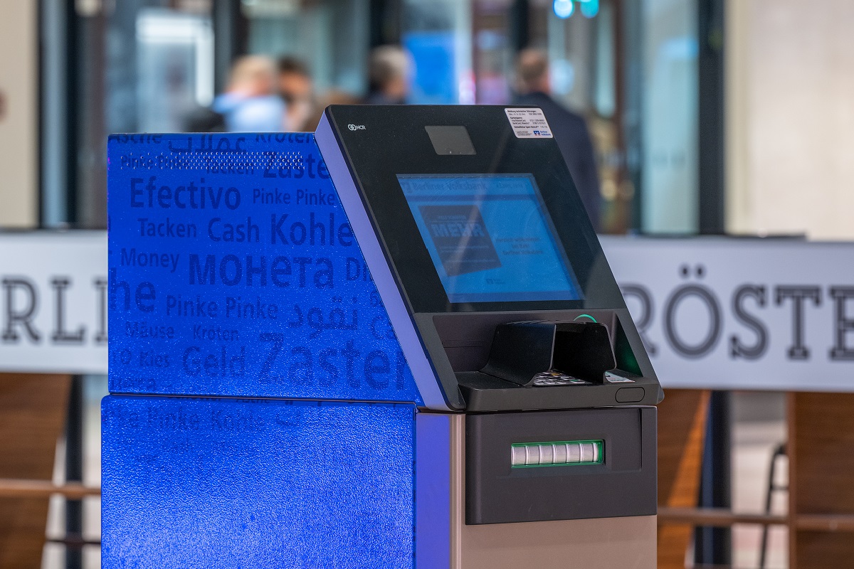 Automat der Berliner Volksbank. Im Hintergrund verschwommen Menschen.