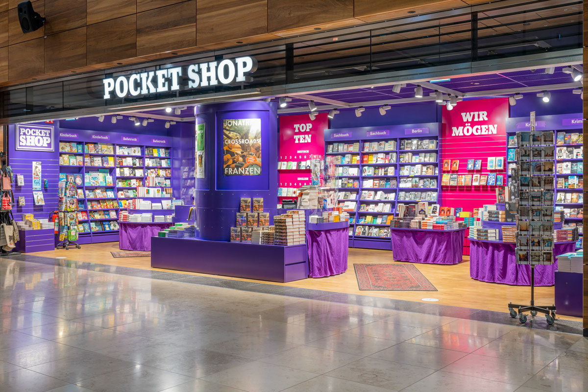 Blick von außen in den Pocket Shop mit seinen lila Regalen.