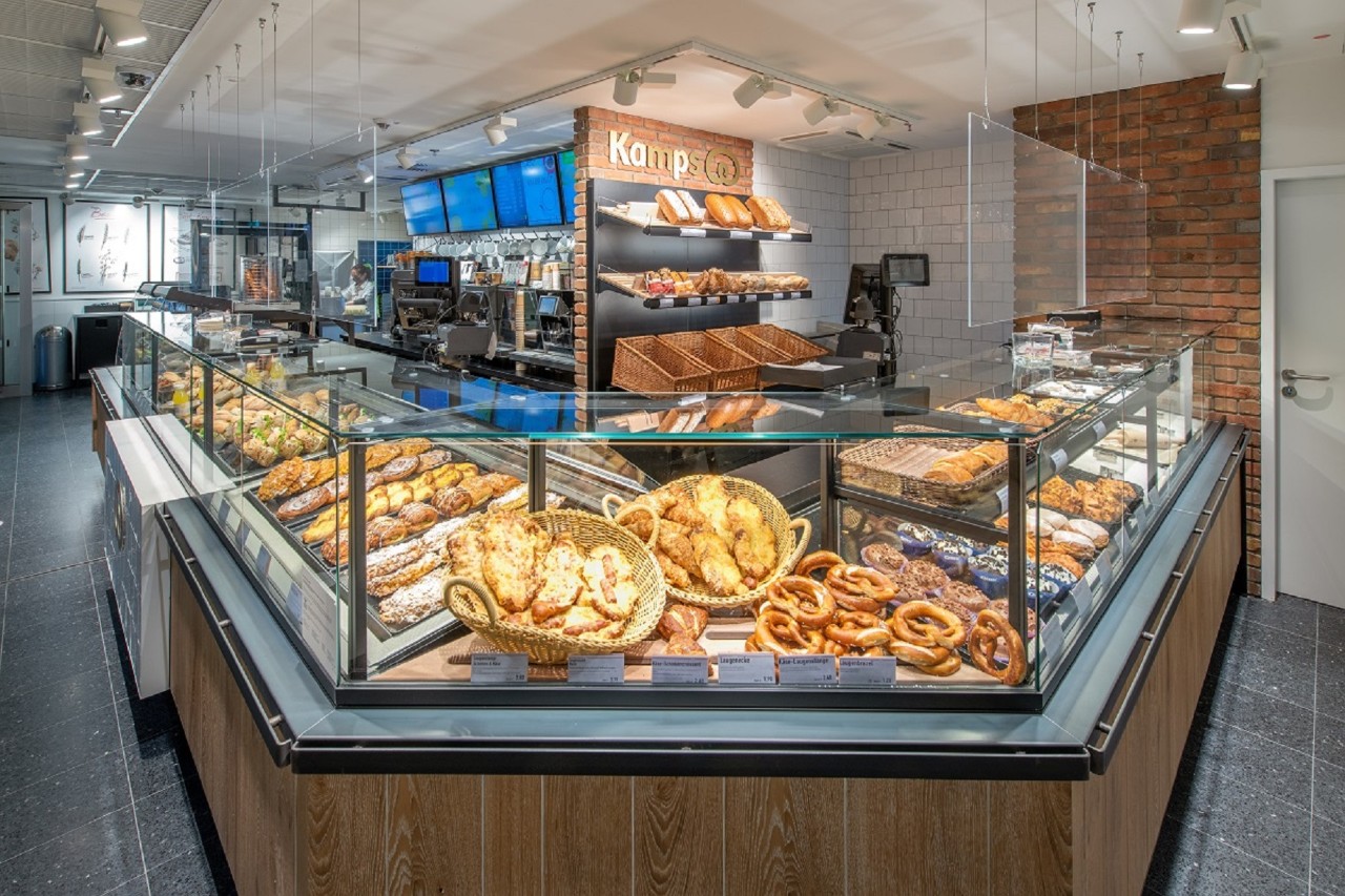 Blick auf die Auslage der Bäckerei. Belegte Brötchen und Kuchen.