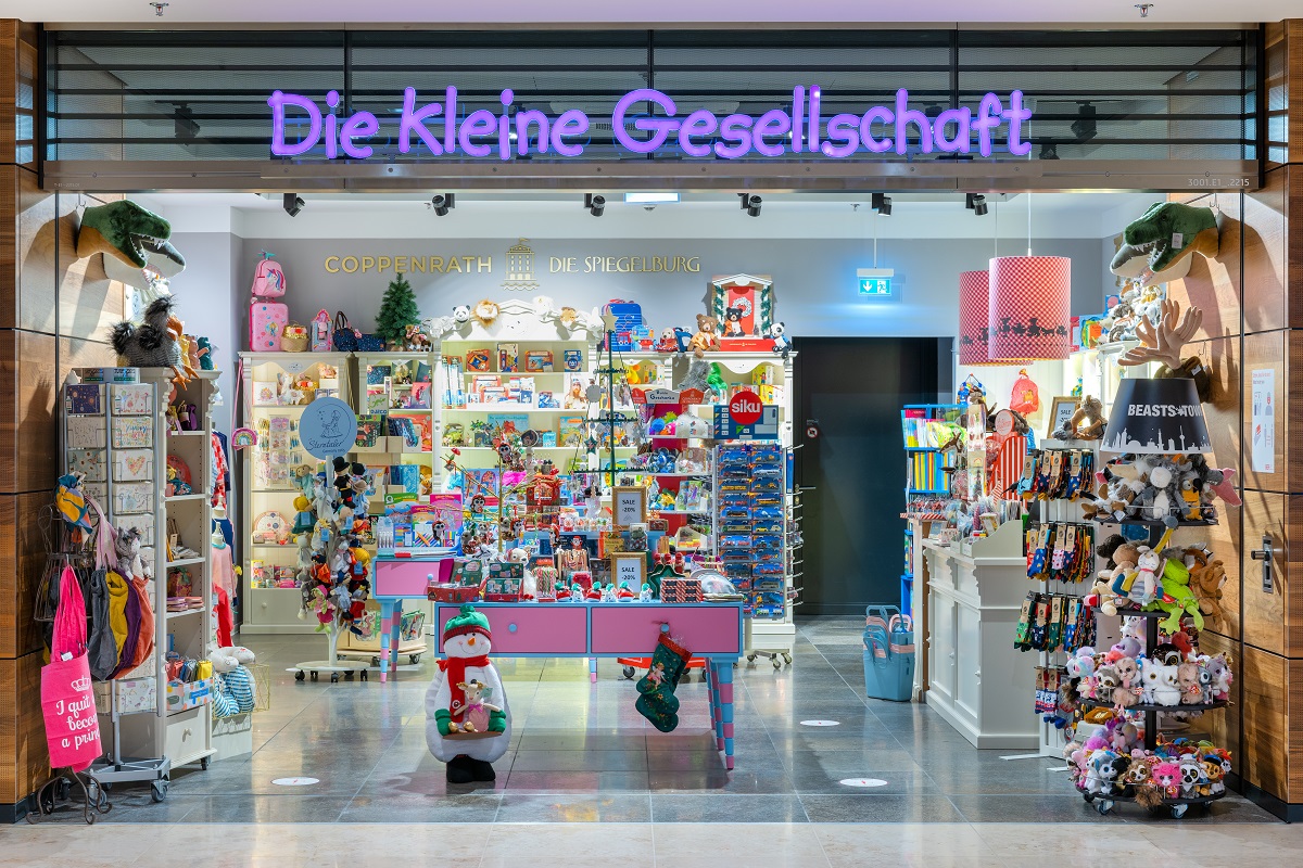 Blick von außen auf das Kindergeschäft. In den Regalen viel Spielzeug und Plüschtiere.