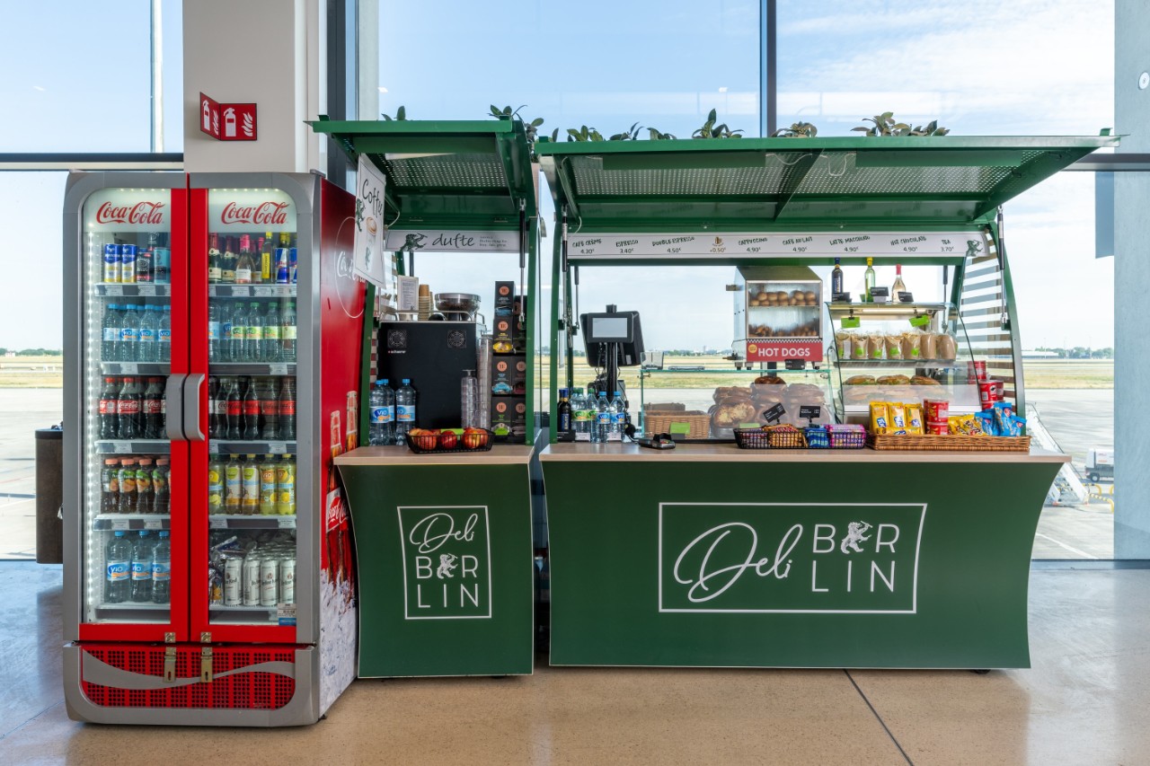 Mobiler Stand mit Essen und Trinken. Daneben ein Getränke-Kühlschrank