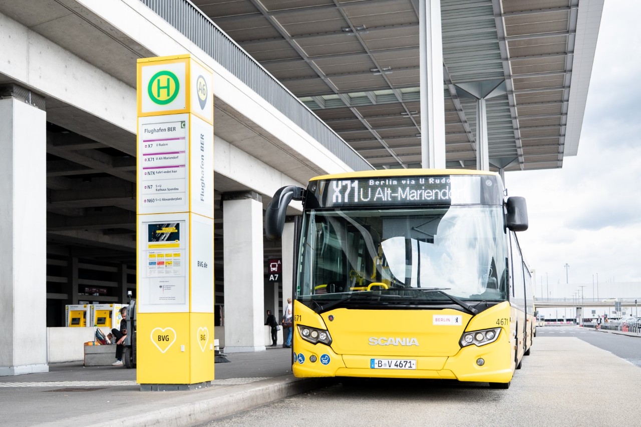 Ein gelber Bus der BVG steht an der Bushaltestelle A direkt am Terminal 1. 