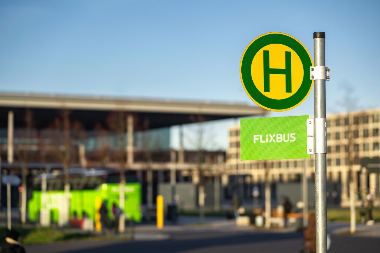 Grüner Bus steht an der Bushaltestelle B. Im Vordergrund ein Bushaltstellenschild.