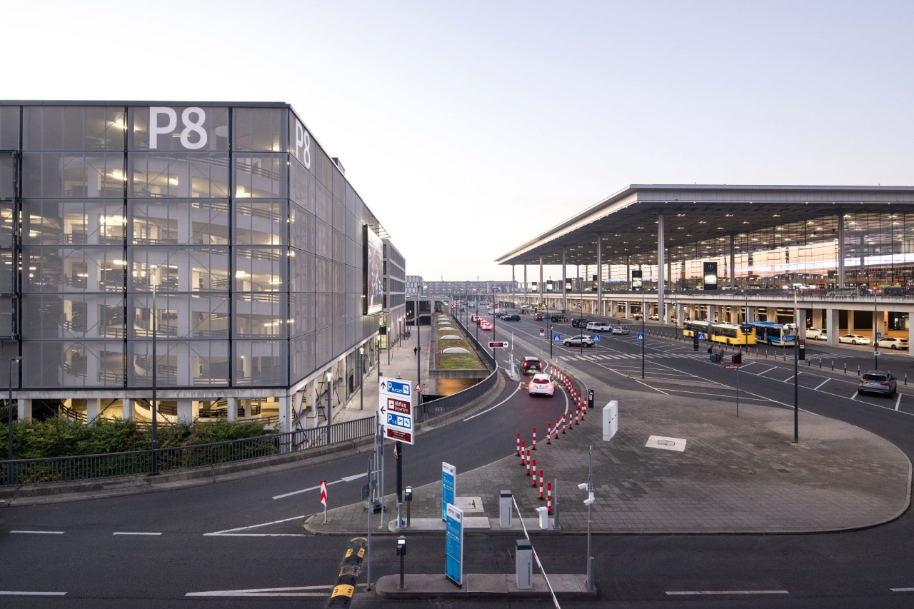 Blick auf die graue Außenhülle des Parkhauses P8. Daneben das Terminal 1. 