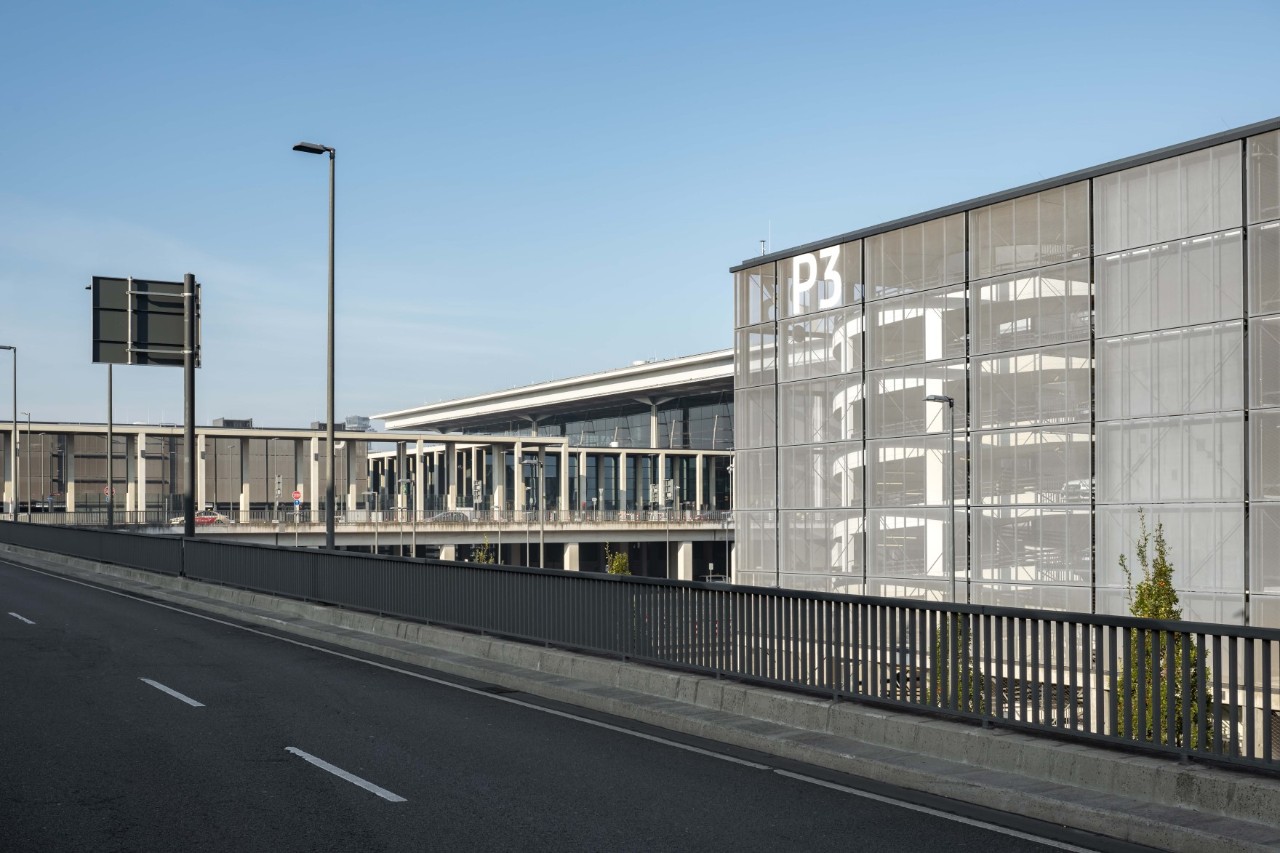 Links die Vorfahrt zum Terminal. Rechts das graue Parkhaus P3. Dahinter das Terminal 1.