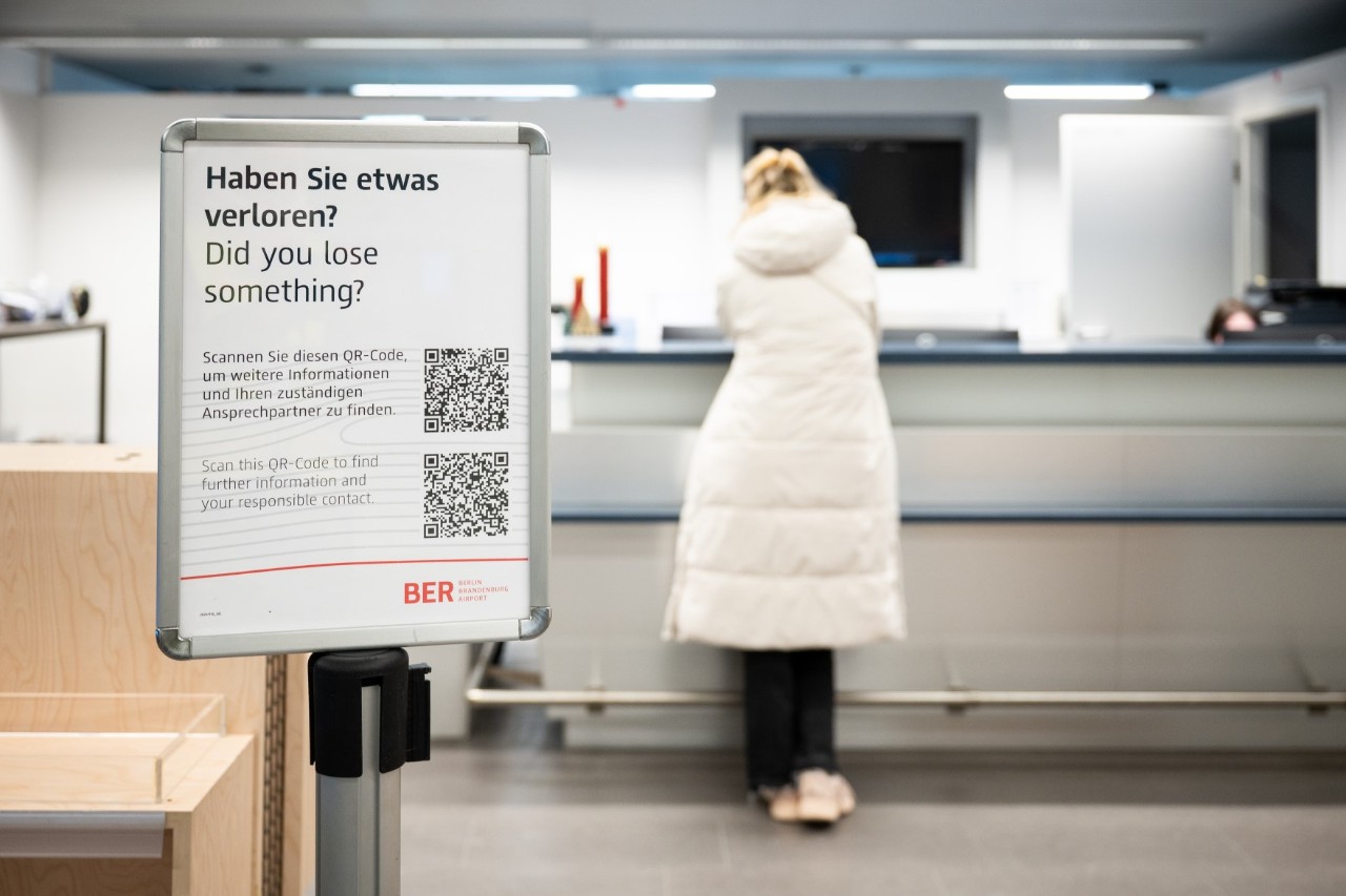 Person steht im ServiceCenter. Davor ein Schild mit Hinweisen.