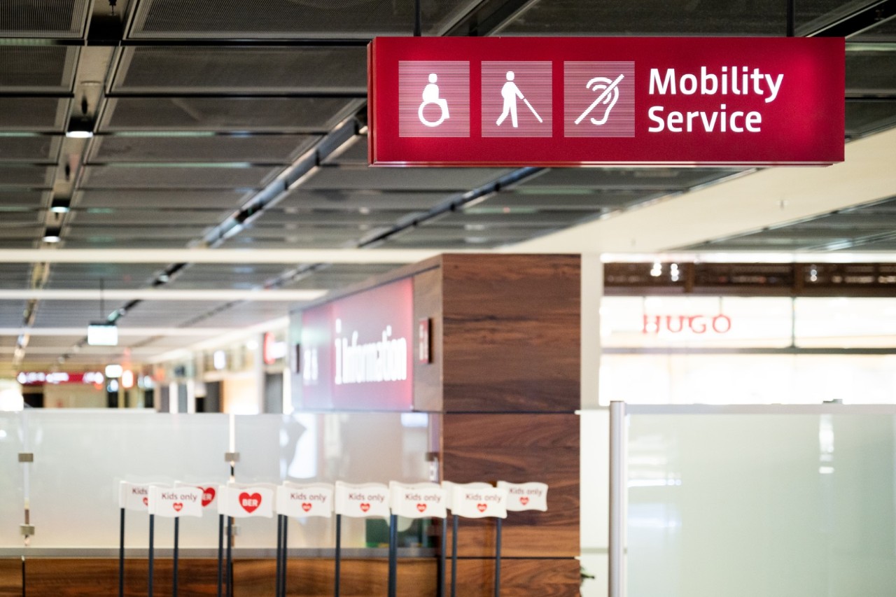 Schild des Mobilty Service vor der Flughafeninformation