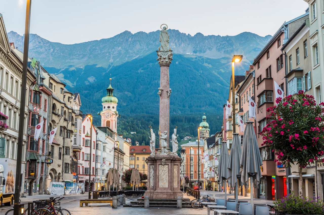 Blick auf Annasäule und Altstadt von Innsbruck mit Bergkulisse.