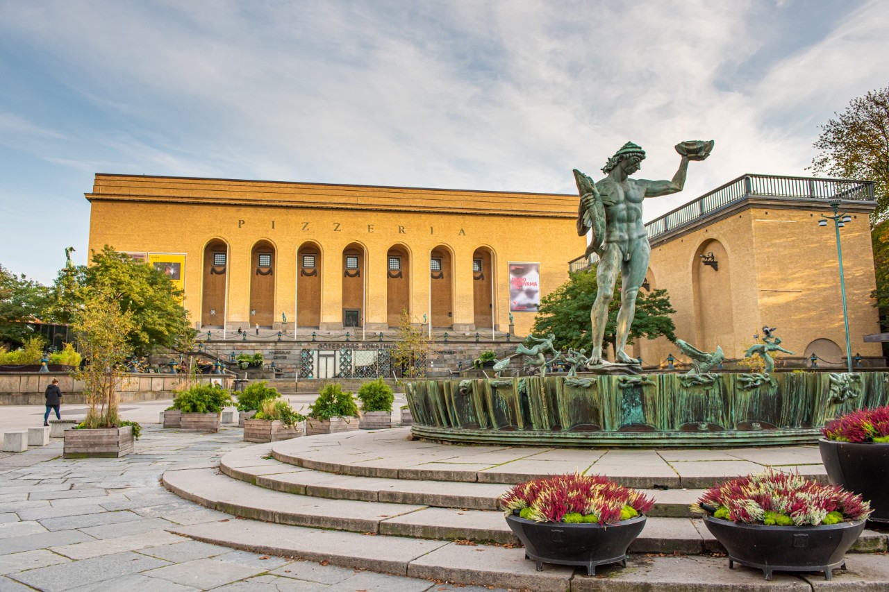 Kunstmuseum mit Poseidon-Figur, bunte Pflanzen, Treppen mit Statue 
