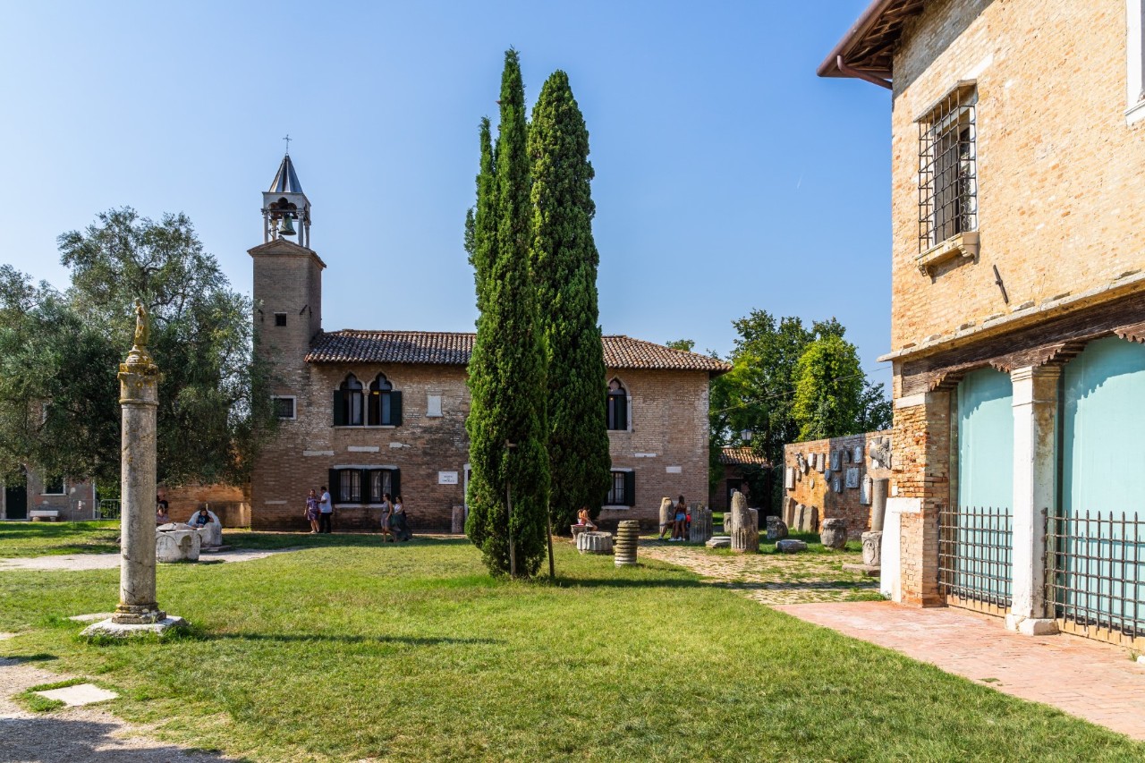 Insel Torcello, Archäologiemuseum mit Glockenturm, Garten mit Cypressen, Statuen und Ausstellungsstücken. © Francesco Bonino/stock.adobe.com 