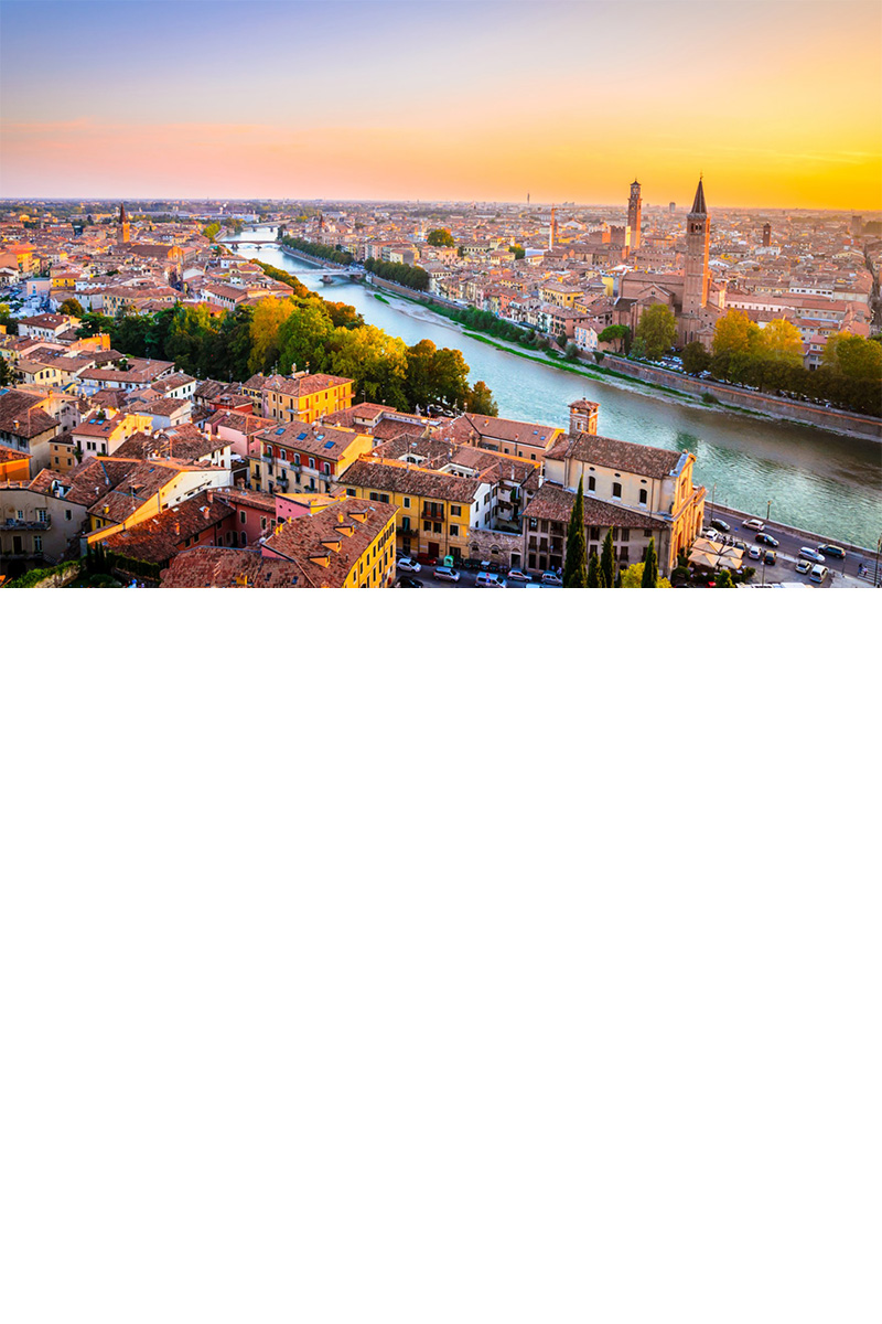 Altstadt von Verona. Im Vordergrund ein Fluss. Dahinter Häuser und Kirchen.