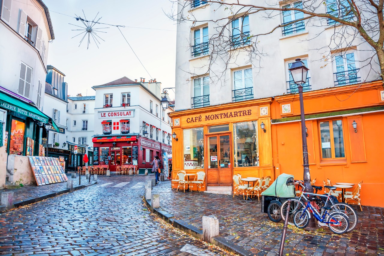 Typisch französische Straße im Viertel Montmartre mit bunten Ladenfronten © MarinadeArt / Adobe Stock