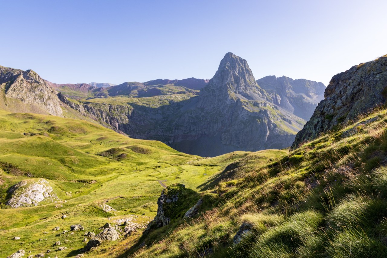 Naturlandschaft mit felsigen Bergen und grünen Hochwiesen.