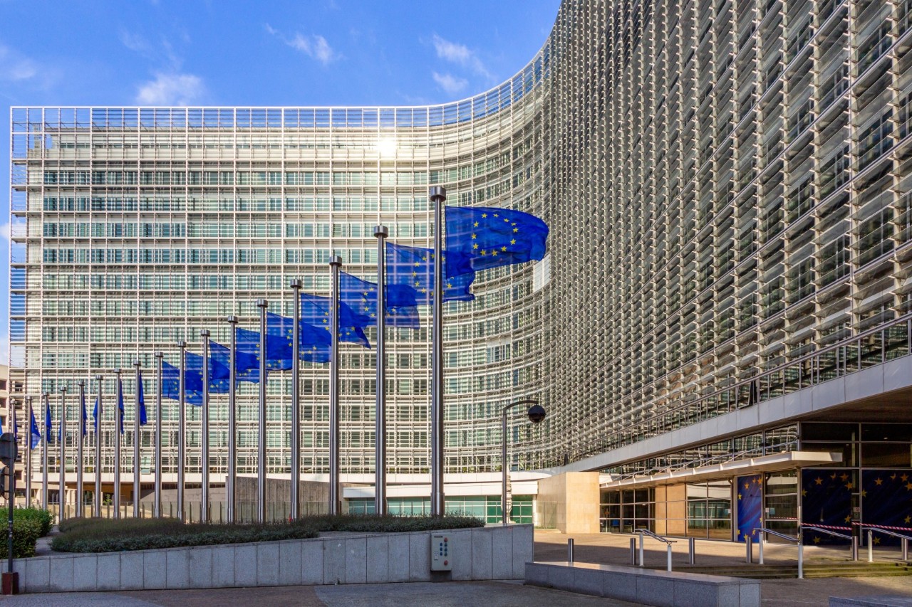 Berlaymont-Gebäude im Sechziger-Jahre-Stil, EU-Fahnen im Vordergrund 