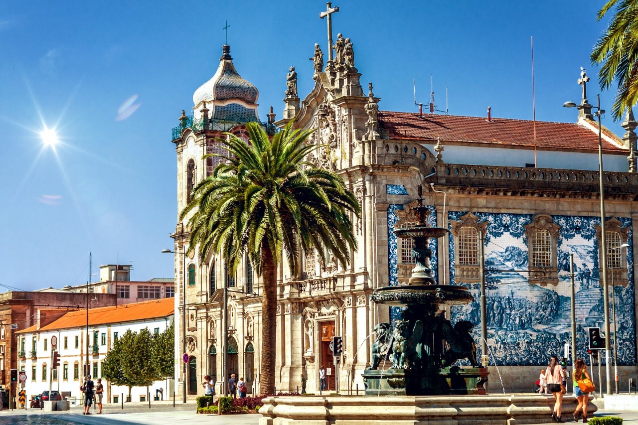Kirche Igreja do Carmo, verziert mit blaubemalten Fliesen, Palmen und Löwenbrunnen im Vordergrund 