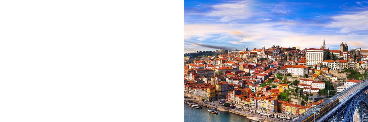 Altstadt von Porto auf einem Hügel. Davor ein Fluss mit einer Brücke.