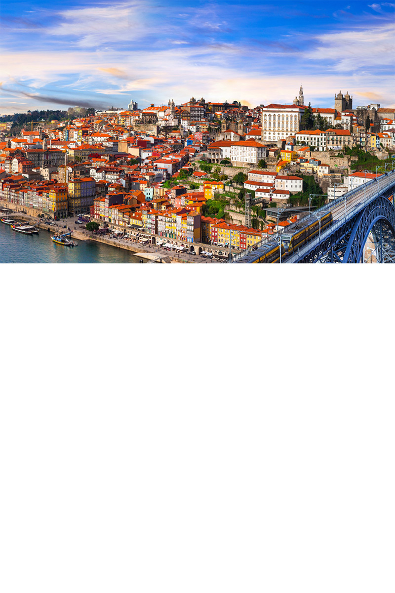 Altstadt von Porto auf einem Hügel. Davor ein Fluss mit einer Brücke.