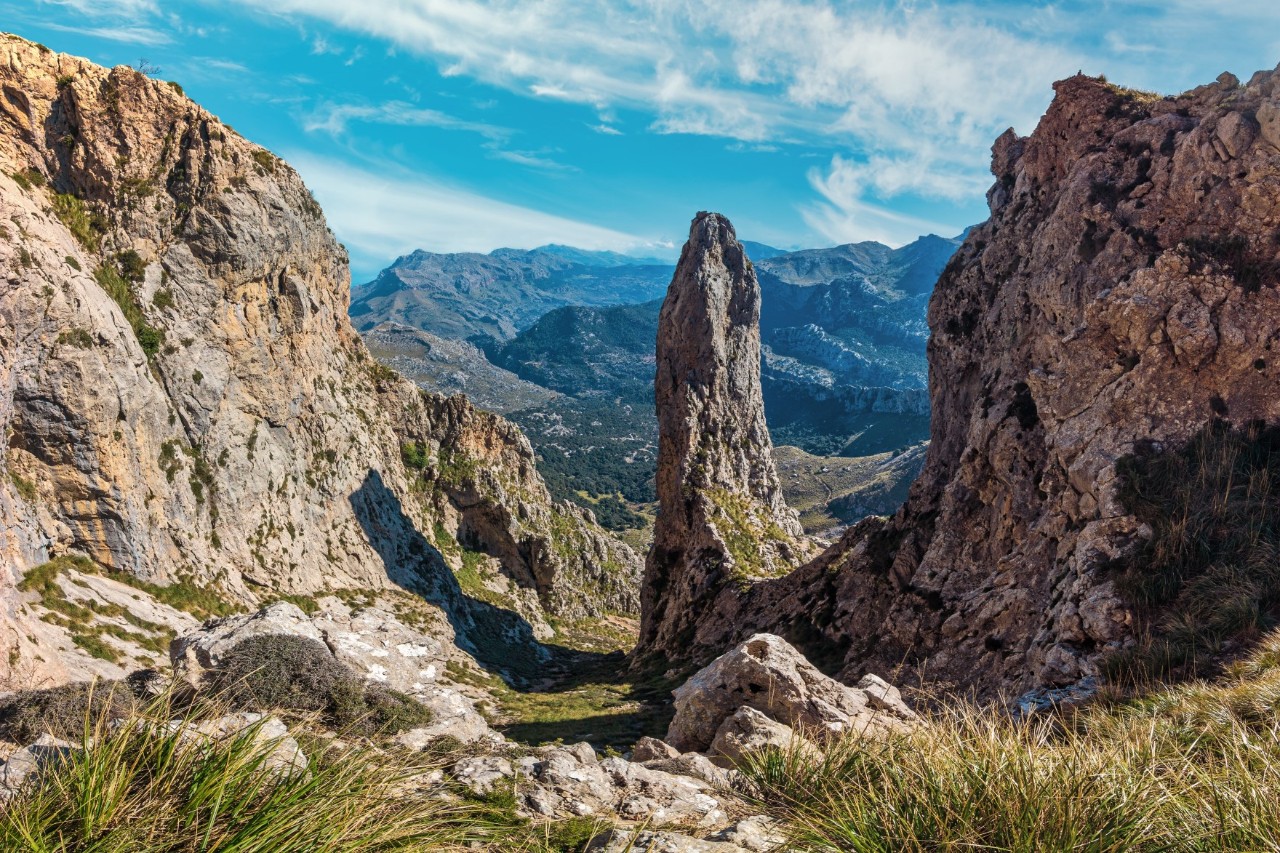 Berglandschaft mit steilen Felswänden im Vordergrund 