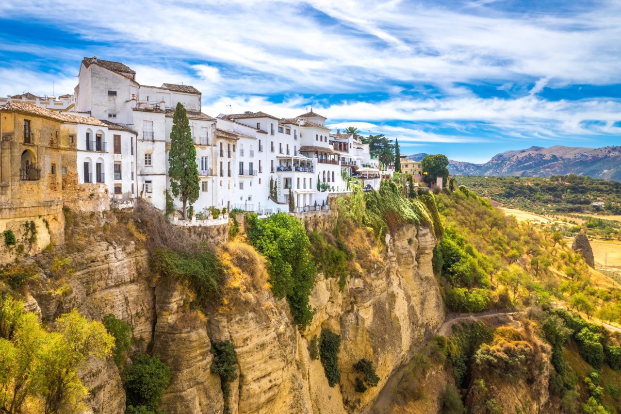 Weiße Häuser auf Felsen über einer tiefen Schlucht in Ronda.