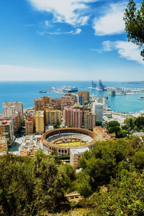 Blick vom Berg auf den Hafen von Malaga mit modernen Gebäuden.