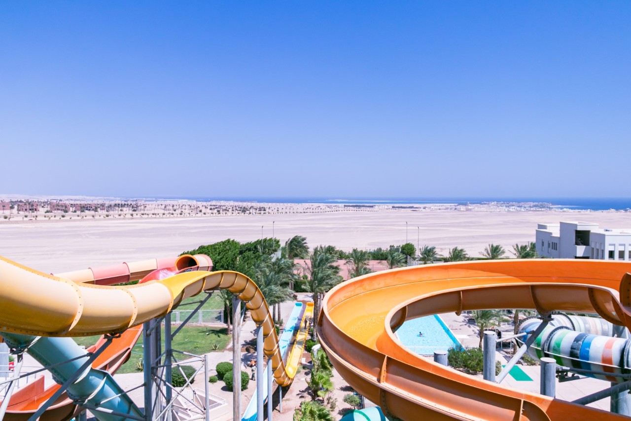Wasserrutschen im Aqua Park, Wüste und Meer im Hintergrund  