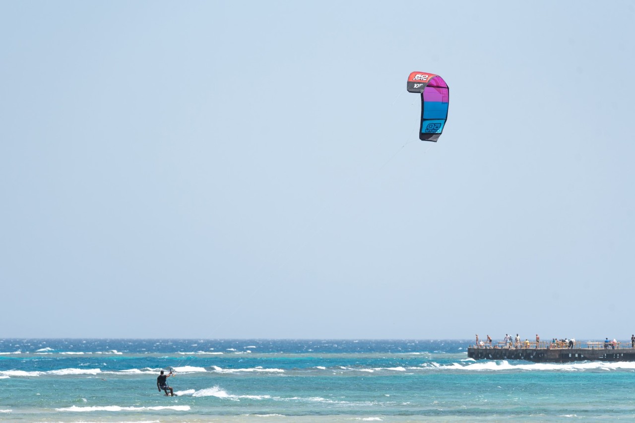 Kitesurfer im Meer, Wellen, Teil einer Seebrücke 
