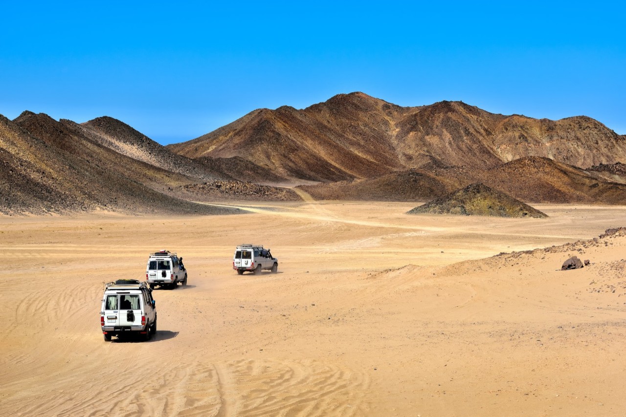 Geländewagen in der Wüste, bergige Landschaft © Dejan Gileski/stock.adobe.com