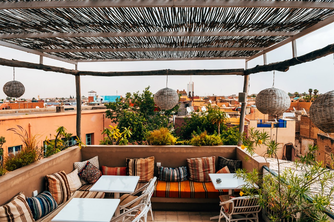 Blick auf eine Dachterrasse in Marrakesch. Im Hintergrund die Stadt.