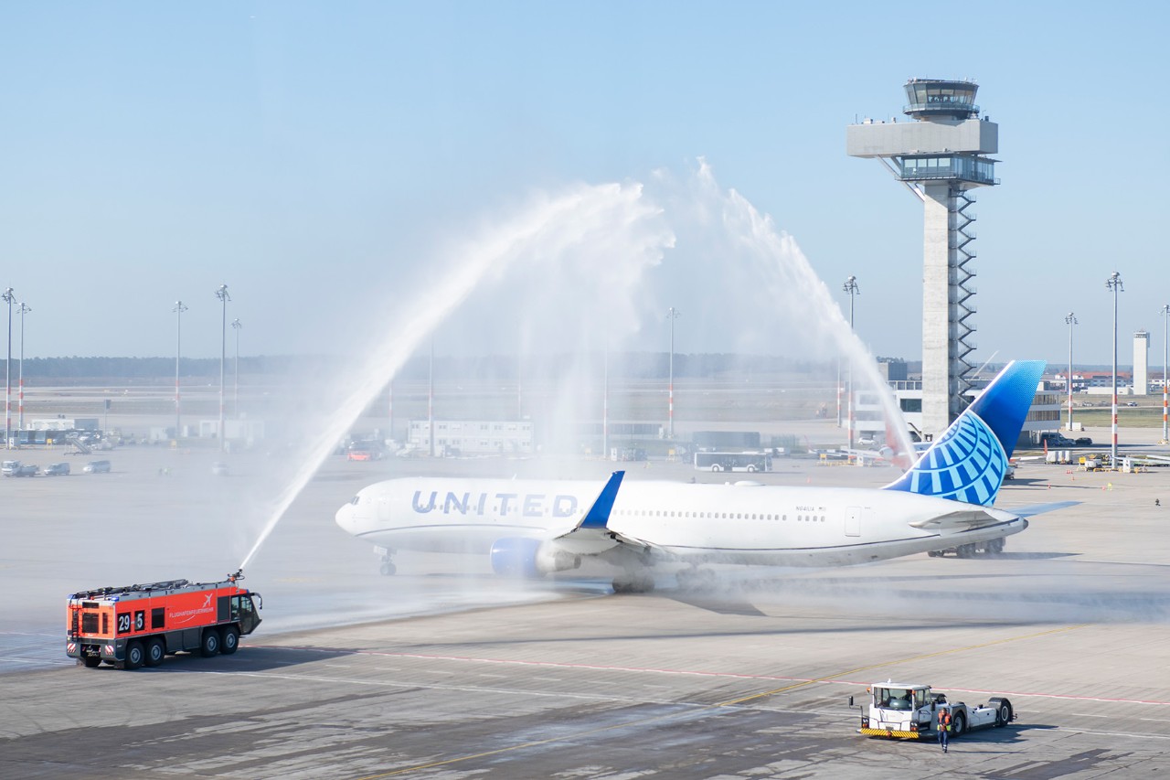 Maschine von United Airlines bei Wasserfontäne durch Flughafenfeuerwehr.