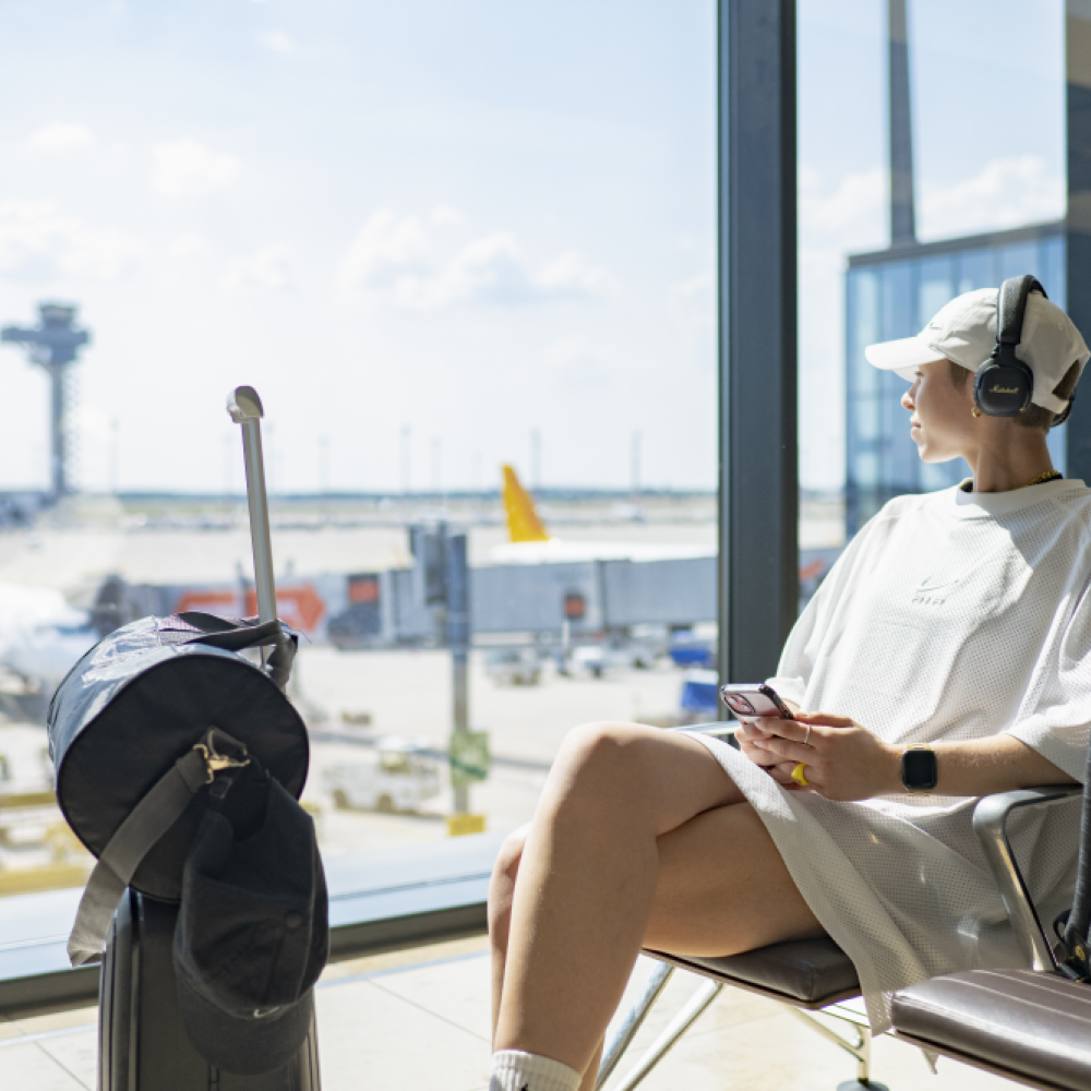Person sitzt in einem Gate im Terminal 1 und blickt auf das Vorfeld