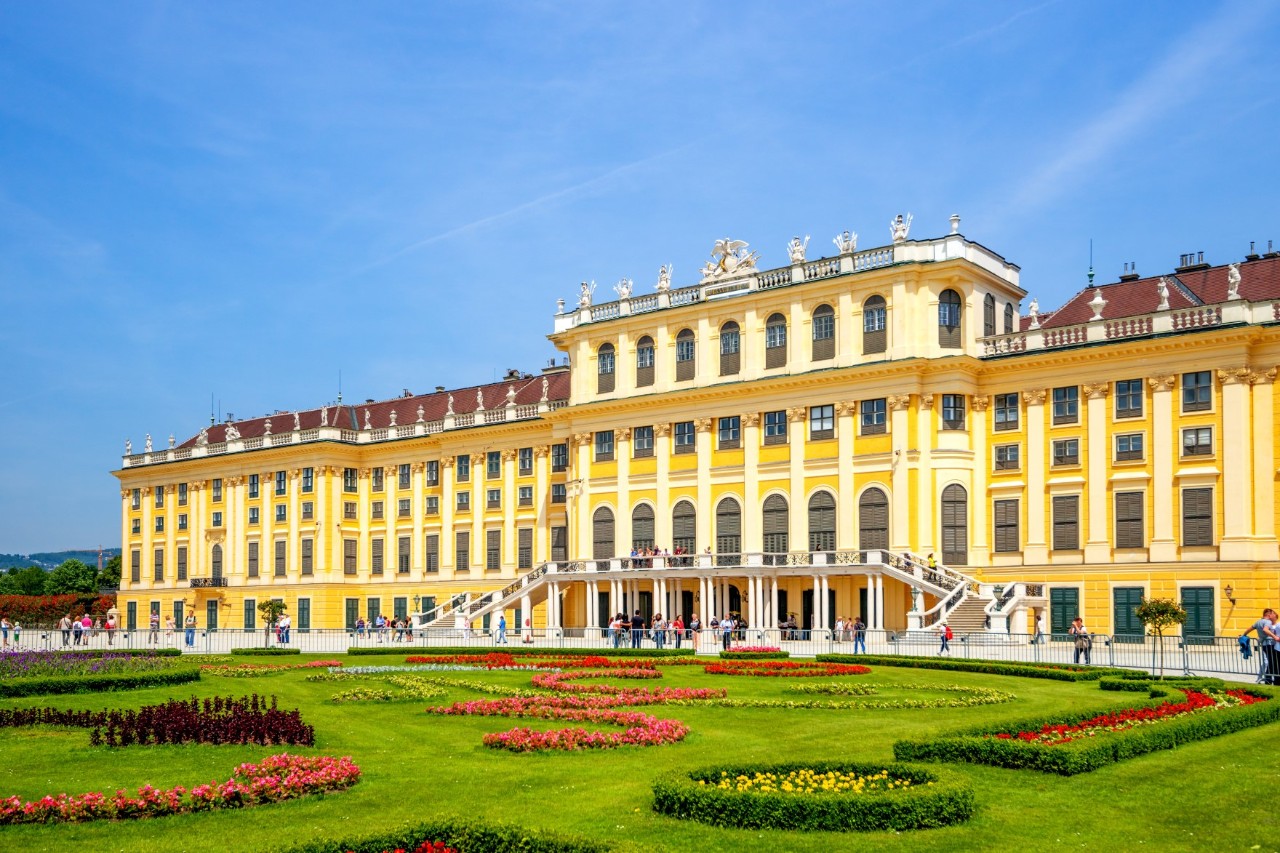 Schloss Schönbrunn mit bunter Blumenpracht im Vordergrund.