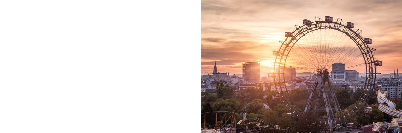 Riesenrad in Wien bei Sonnenuntergang mit Skyline im Hintergrund.