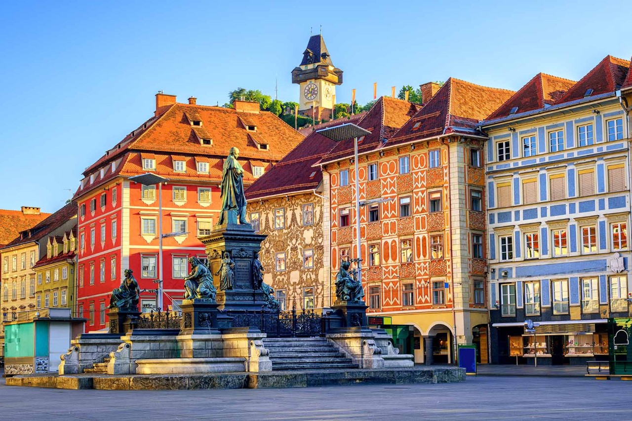 Grazer Marktplatz mit historischen Fassaden und Marktständen bei Sonnenschein.
