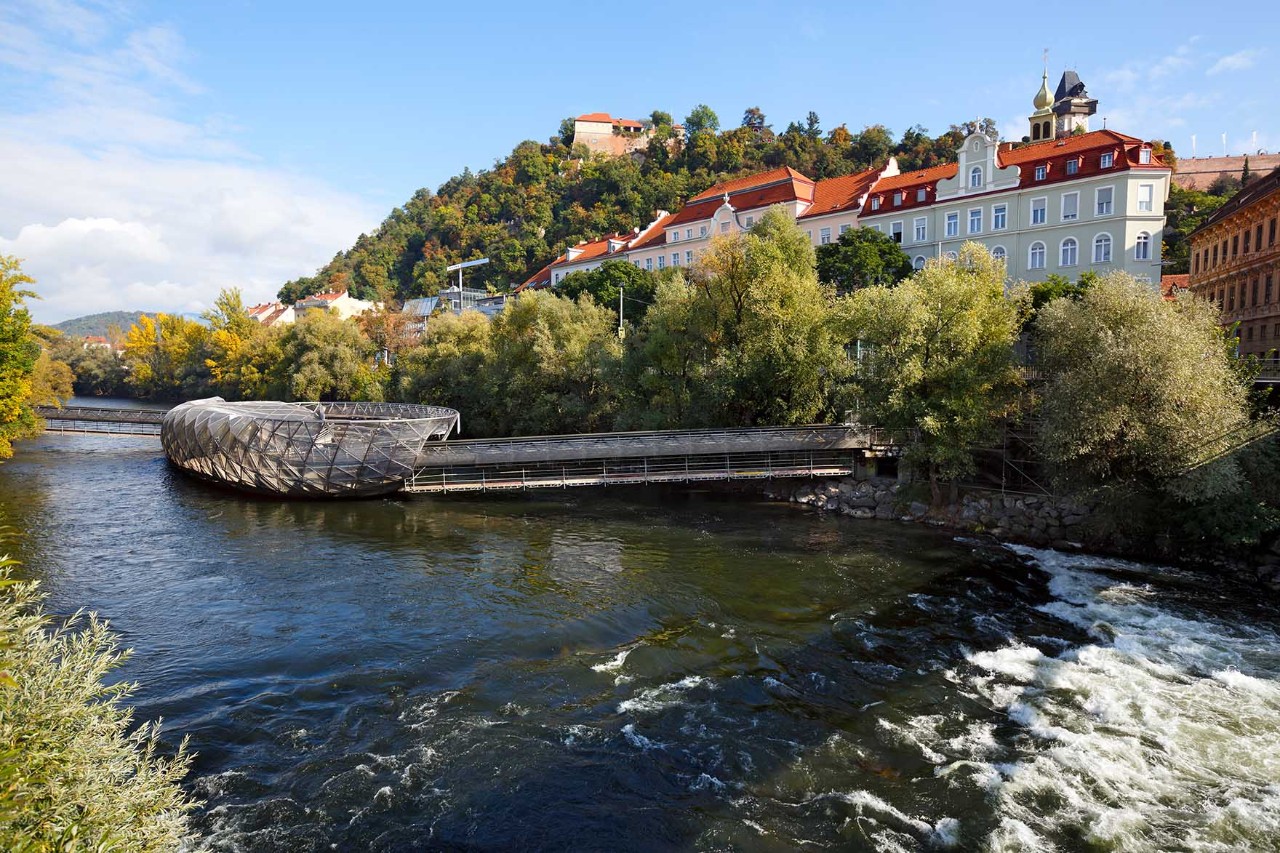 Moderne Murinsel in Graz mit geschwungener Stahlstruktur über der Mur.