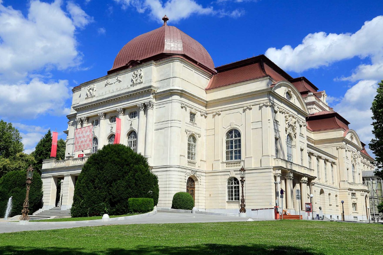 Grazer Opernhaus mit Kuppel, Statuen und klassizistischer Fassade bei Sonnenschein.
