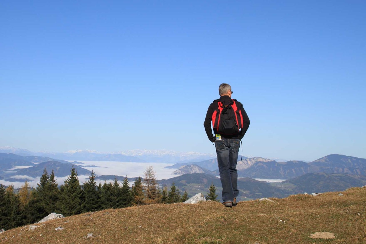 Schöckl bei Graz mit Wanderweg, grüner Wiese und Fernblick ins Tal.