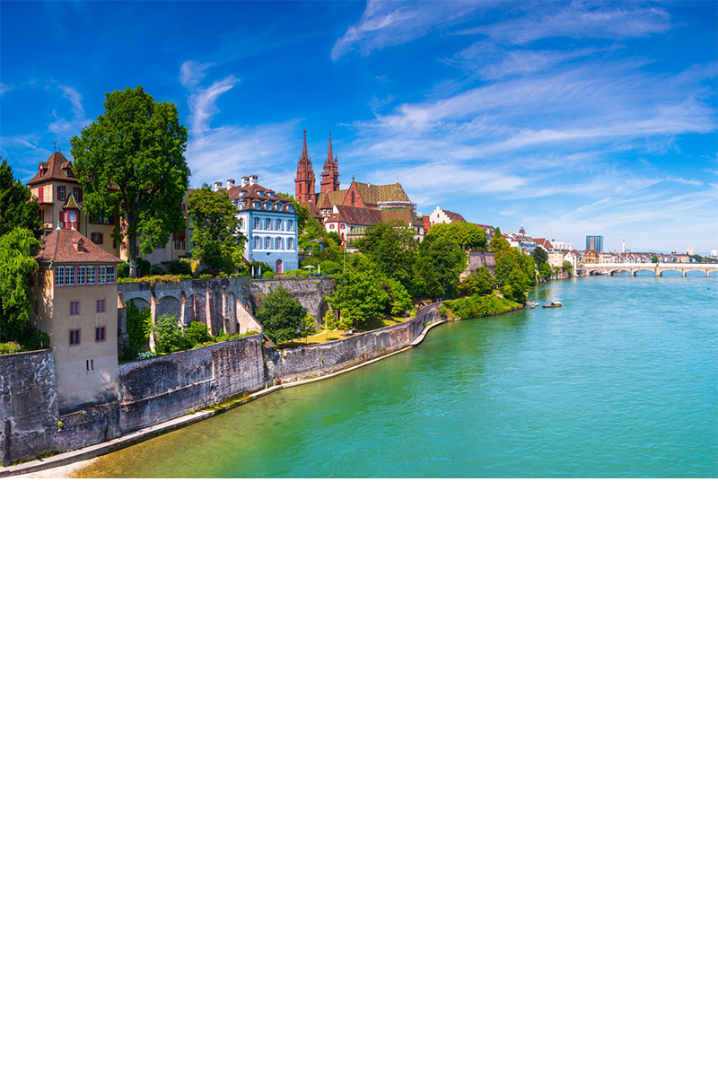 Blaugrüner Fluss Rhein und die linksseitige Altstadt von Basel mit dem roten Münster 
