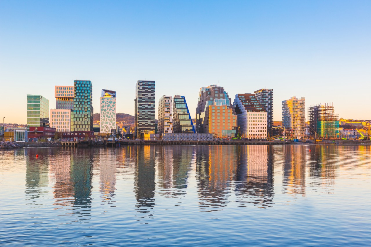 Silhouette von Bjørvika in Oslo spiegelt sich im ruhigen Wasser.