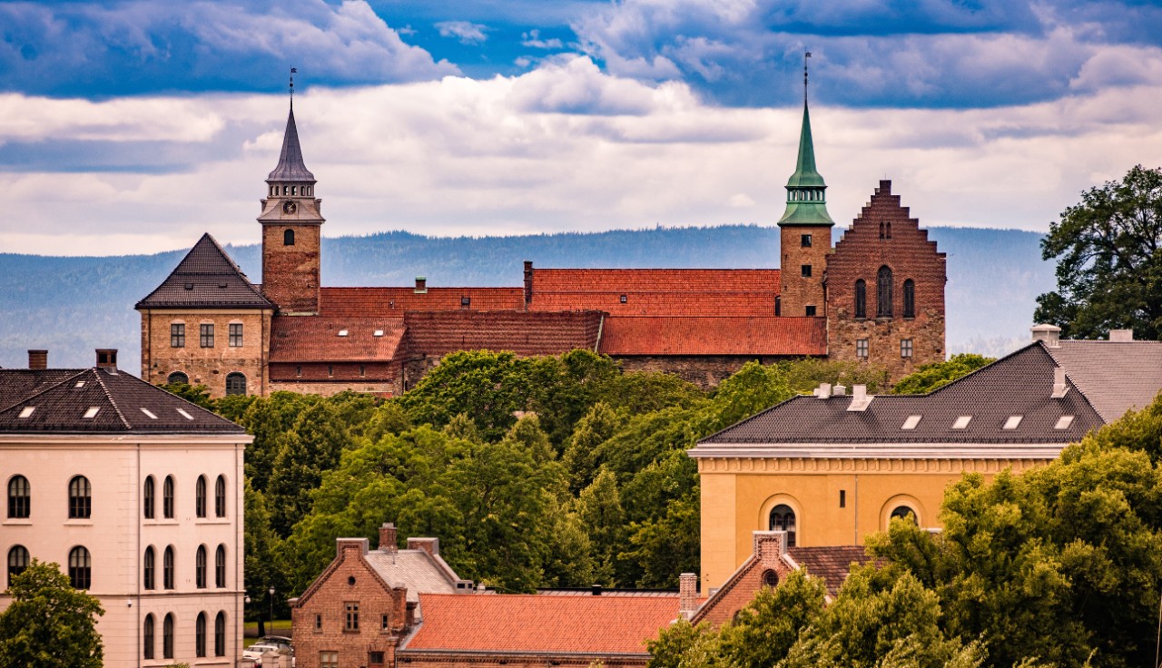 Burg Akershus in Oslo mit Bäumen im Vordergrund.