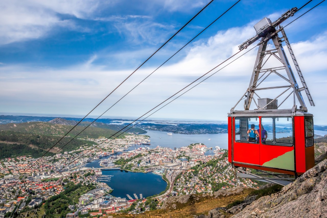 Gondelbahn zum Berg Ulriken vor bewaldetem Hang bei Tageslicht.