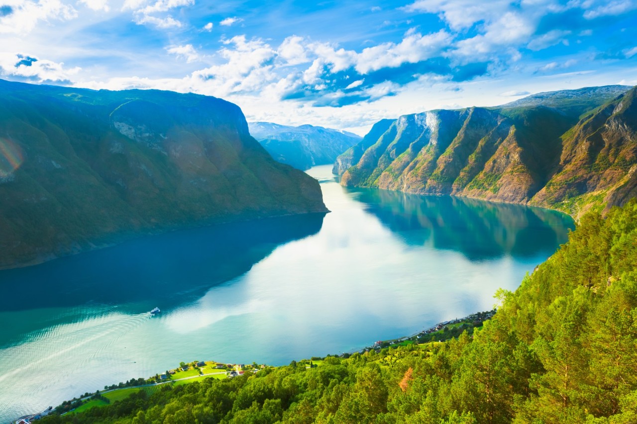 Luftbild vom Sognefjord mit Wasser, Bergen und grünen Hängen.