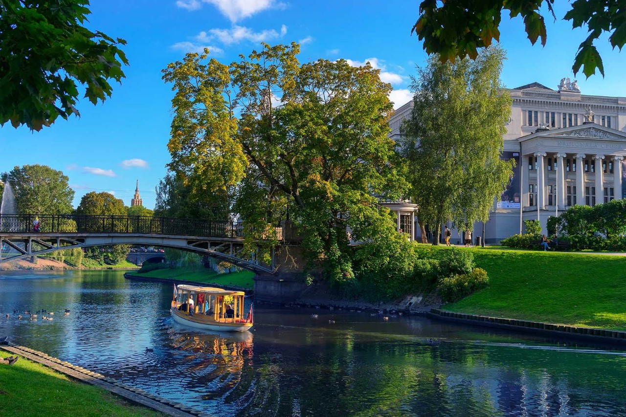Fluss Düna mit Brücke und Stadtpanorama bei Sonnenuntergang.