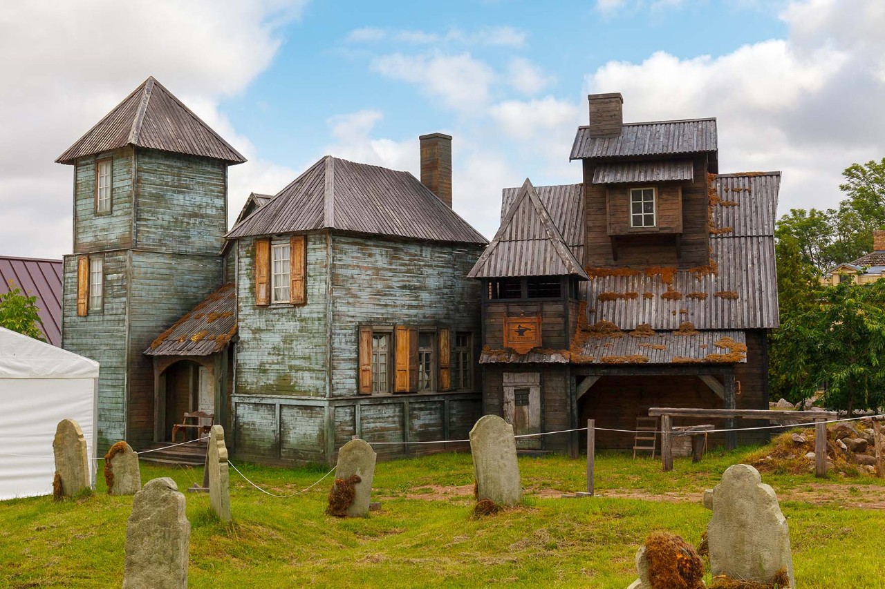 Historisches Holzhaus im ethnischen Freilichtmuseum umgeben von Wald.