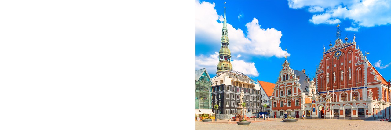 Altstadt von Riga mit bunten Häusern und Kirchturm bei Tageslicht.