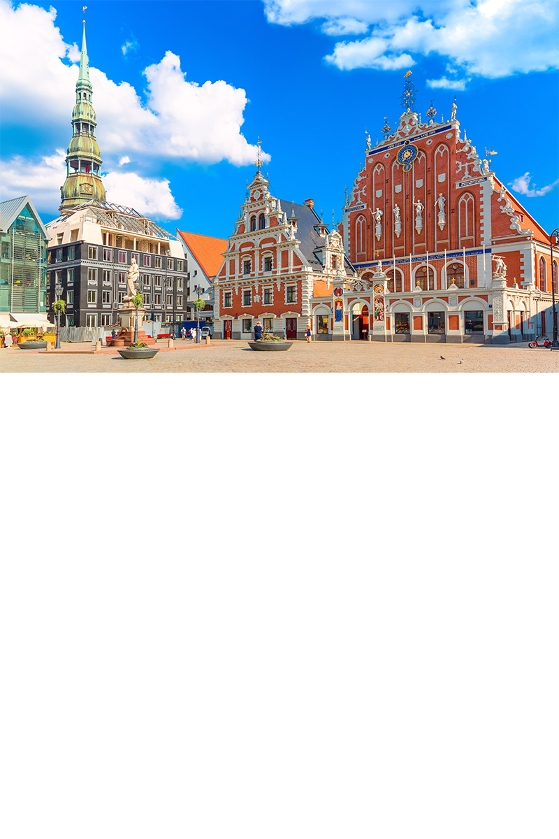 Altstadt von Riga mit bunten Häusern und Kirchturm bei Tageslicht.